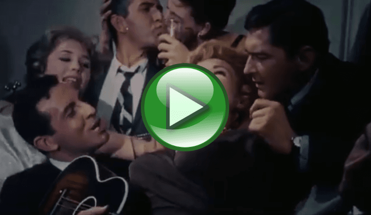 A video thumbnail showing several people gathered closely in a lively indoor setting, including one person holding a guitar while others appear to talk or laugh (score 0.2099).